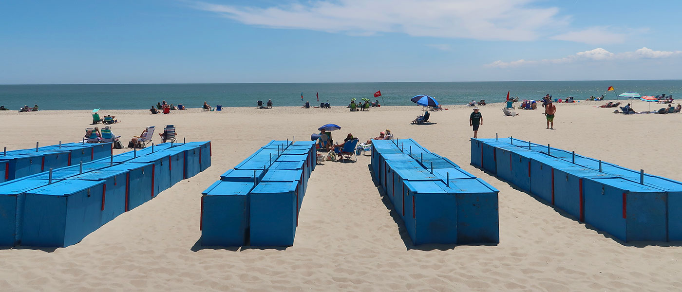 Blue beach boxes lined up on the sand